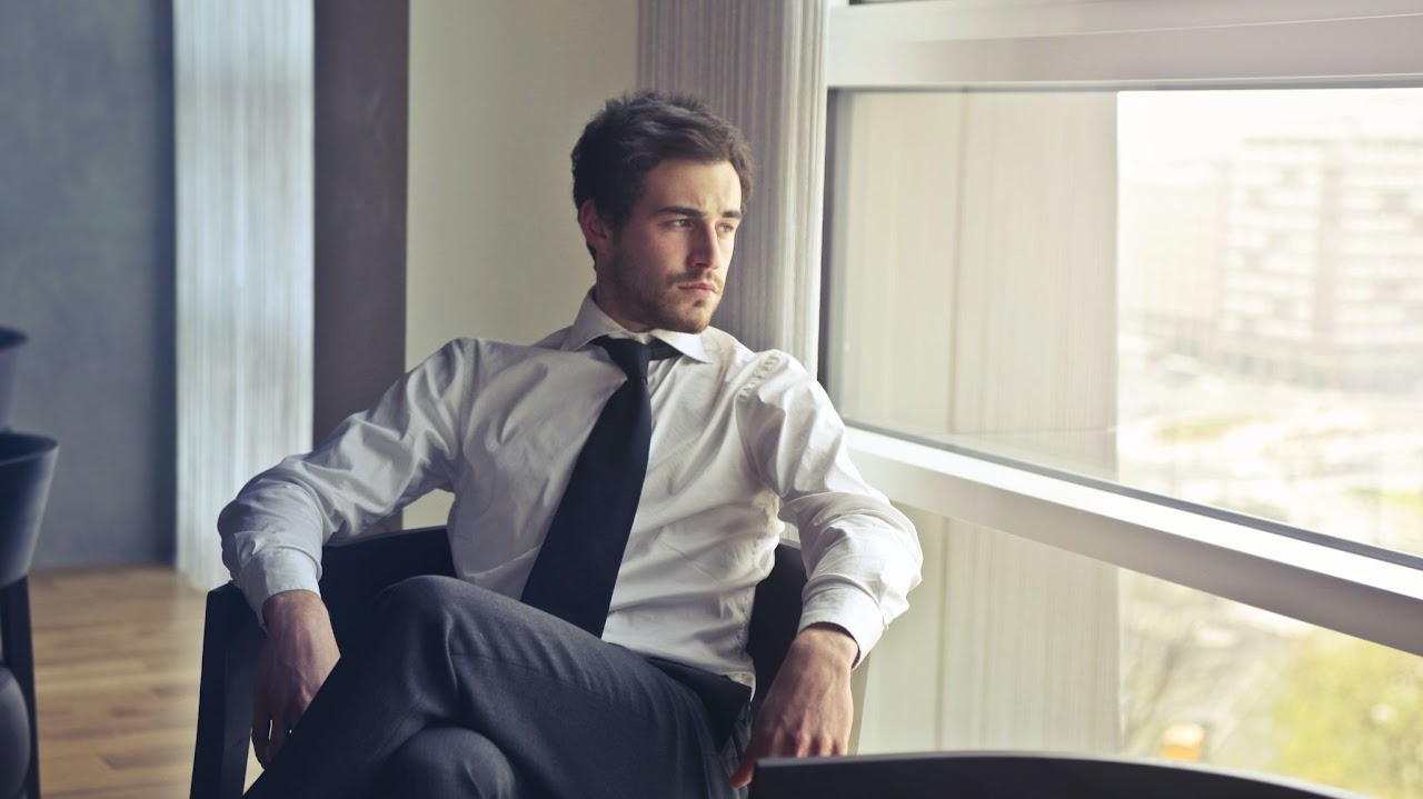 Confident man sitting in chair with legs crossed